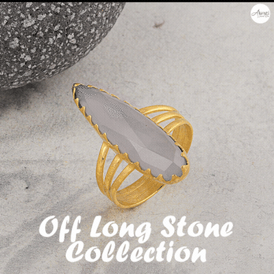 A Gold Ring With A Green Stone Sits On A Table With The Words Off Long Stone Collection Above It GIF