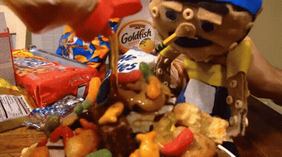A Goldfish Cracker Is Being Poured Over A Pile Of Candy GIF