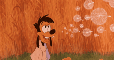 A Goofy Cartoon Character Blowing Dandelions With A Magnifying Glass On His Head GIF