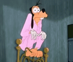 A Goofy Cartoon Character Is Sitting On A Chair With His Hands On His Knees . GIF