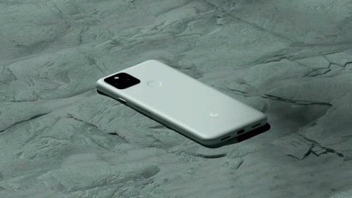 A Google Phone Is Laying On Its Back On A Rocky Surface GIF