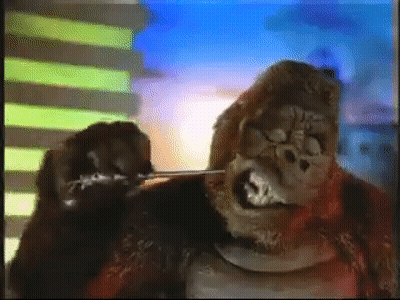 A Gorilla Is Standing In Front Of A Building . GIF