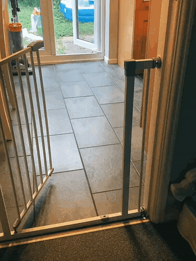 A Gray Tile Floor With A White Gate Between The Door And The Floor GIF