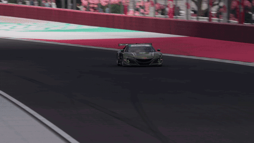 A Green Acura Race Car Is Driving On A Race Track GIF
