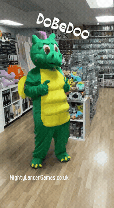 A Green And Yellow Dragon Mascot Is Standing In A Store With The Words Dobedoo On The Top GIF