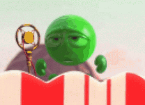 A Green Ball With A Sad Face Is Holding A Microphone In Front Of A Striped Popcorn Box GIF