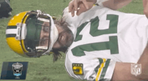 A Green Bay Packers Football Player Is Laying On The Ground GIF