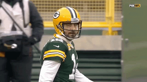 A Green Bay Packers Football Player Is Wearing A Helmet And Looking At The Camera . GIF