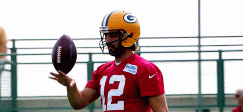 A Green Bay Packers Player Wearing A Red Jersey With The Number 12 On It GIF