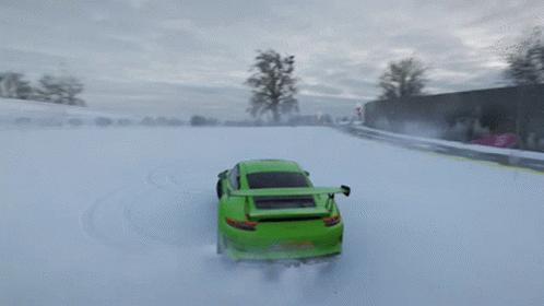 A Green Car Is Driving Through The Snow On A Road GIF
