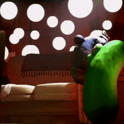A Green Cartoon Character Is Sitting On A Couch In A Room GIF