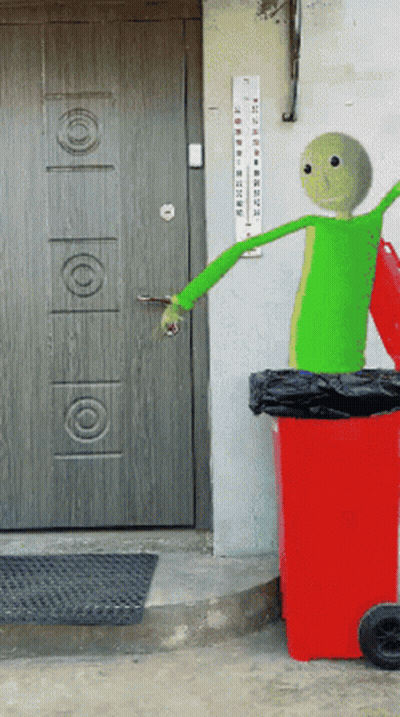 A Green Cartoon Character Is Standing Next To A Red Garbage Can GIF