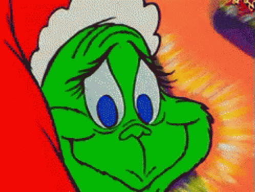 A Green Cartoon Character With Blue Eyes And A Santa Hat On GIF