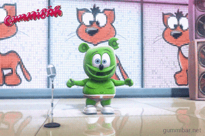 A Green Gummy Bear Is Dancing In Front Of A Microphone With The Words Gummibar Written On The Screen Behind Him GIF