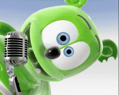 A Green Gummy Bear With Blue Eyes Is Singing Into A Silver Microphone GIF