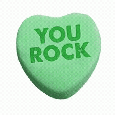 A Green Heart Shaped Candy With The Words `` You Rock '' Written On It . GIF