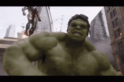 A Green Hulk Is Standing In Front Of A Statue Of A Man GIF