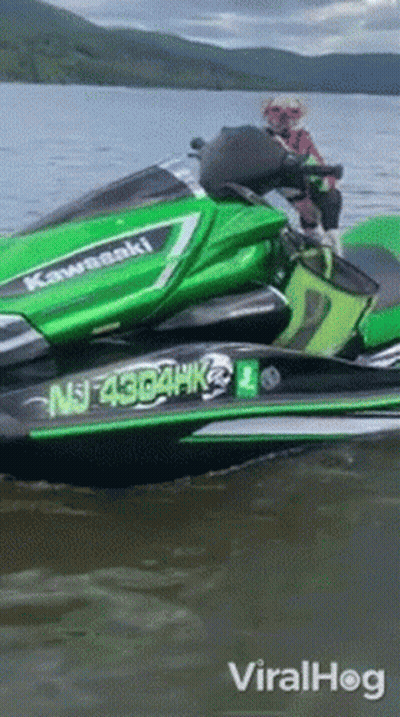A Green Kawasaki Jet Ski Is Floating On The Water GIF