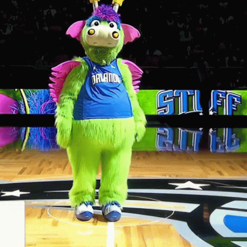 A Green Mascot Wearing A Blue Jersey That Says Orlando GIF