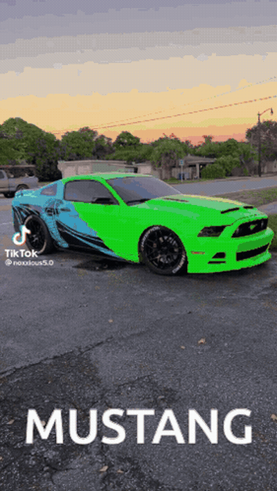 A Green Mustang Is Parked In A Parking Lot At Sunset GIF