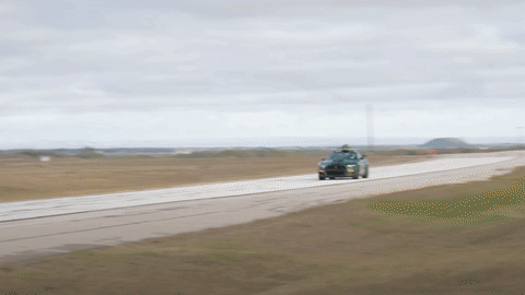 A Green Mustang With A Surfboard On Top Of It GIF