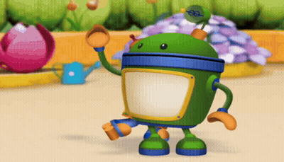 A Green Robot Is Standing In Front Of A Flower Bed GIF