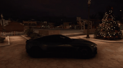 A Green Sports Car Is Parked Near A Christmas Tree GIF