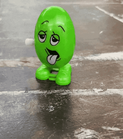 A Green Toy With A Face On It Sticking Out Its Tongue GIF