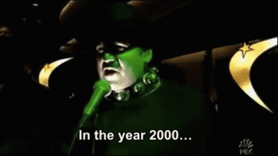 A Green Witch Singing Into A Microphone With The Words In The Year 2000 GIF