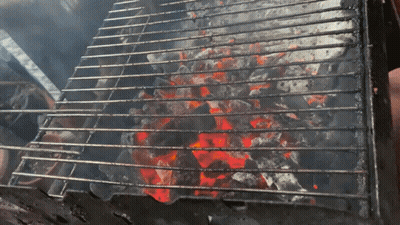 A Grill With A Lot Of Coals On It And Smoke Coming Out Of It GIF