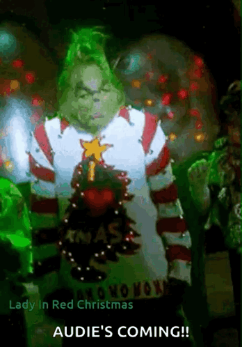 A Grinch In A Christmas Sweater With The Words Lady In Red Christmas Audie 'S Coming On The Bottom GIF