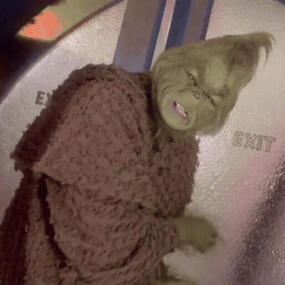 A Grinch Is Standing In Front Of A Glass Door That Says Exit GIF