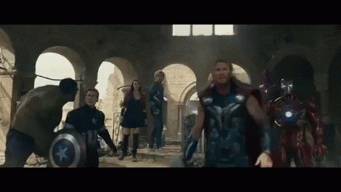 A Group Of Avengers Are Standing In A Room . GIF