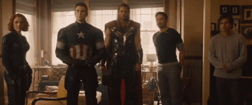 A Group Of Avengers Standing In A Living Room Including Captain America GIF