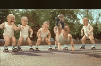 A Group Of Babies Are Rollerblading On A Road . GIF