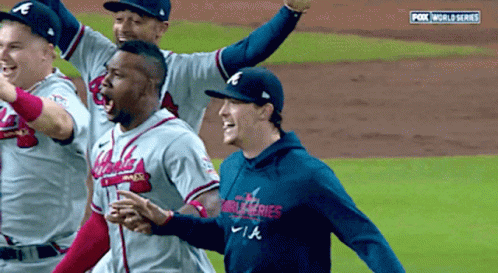 A Group Of Baseball Players Are Celebrating On A Field With Fox World Series In The Background GIF
