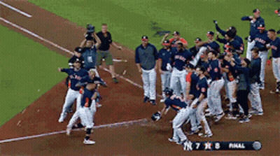 A Group Of Baseball Players Are Celebrating On The Field With A Scoreboard That Says Final GIF