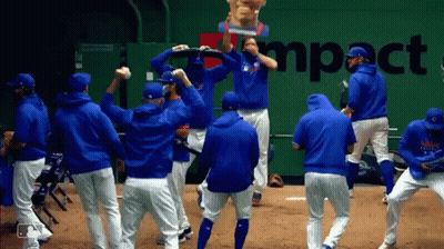 A Group Of Baseball Players Are Dancing In Front Of A Wall That Says Impact GIF