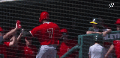 A Group Of Baseball Players Are Giving Each Other A High Five While Standing In Front Of A Net . GIF