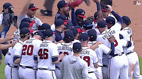 A Group Of Baseball Players Are Huddled Together And One Of Them Has The Number 20 On His Jersey GIF