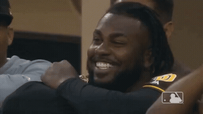 A Group Of Baseball Players Are Hugging And Smiling GIF