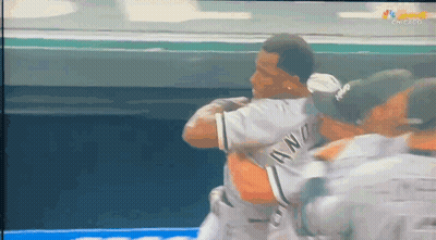 A Group Of Baseball Players Are Hugging Each Other And One Of Them Is Wearing A Jersey That Says ' Awn ' GIF