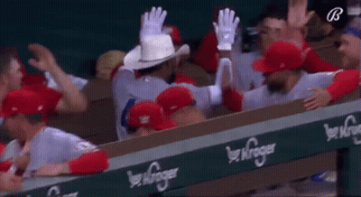 A Group Of Baseball Players Are Sitting In A Dugout . GIF