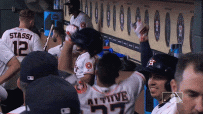 A Group Of Baseball Players Are Sitting In A Dugout And One Of Them Has The Number 27 On His Back GIF