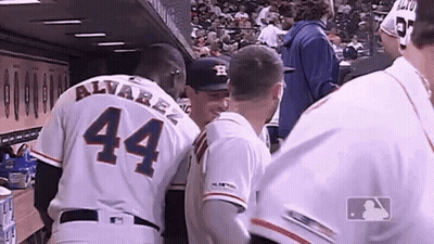 A Group Of Baseball Players Are Standing In A Dugout And One Of Them Has The Number 44 On His Back . GIF