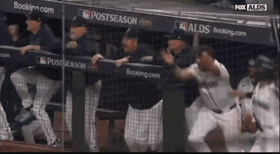 A Group Of Baseball Players Are Standing In A Dugout With A Sign That Says Postseason GIF