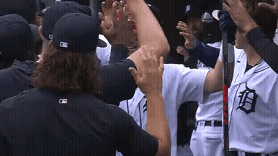 A Group Of Baseball Players Are Standing In A Huddle And Giving Each Other A High Five . GIF