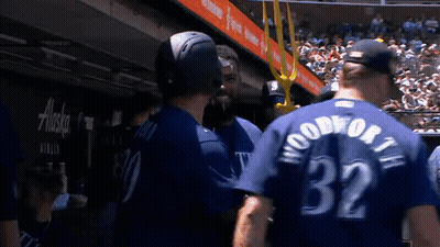 A Group Of Baseball Players Are Standing Next To Each Other In A Dugout . GIF