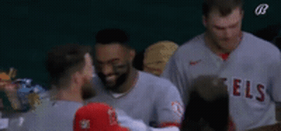 A Group Of Baseball Players Are Standing Next To Each Other On The Field . GIF