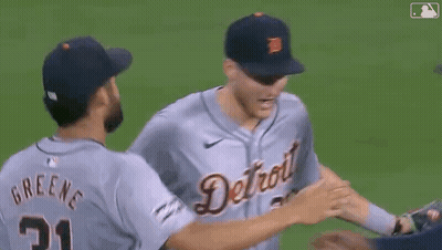 A Group Of Baseball Players Hugging Each Other On The Field GIF